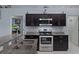 Modern kitchen featuring stainless steel appliances, granite countertops, and dark wood cabinets at 10149 Rockbay Rd, Brooksville, FL 34601