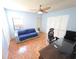 Bright bedroom with light blue walls, tile flooring, and modern ceiling fan at 10244 Hoover St, Spring Hill, FL 34608