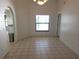 A vacant dining room area showing neutral color walls, tile flooring, and a large window at 10244 Hoover St, Spring Hill, FL 34608