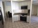 Bright kitchen with white cabinetry, stainless appliances, and tile flooring at 10244 Hoover St, Spring Hill, FL 34608