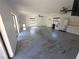 Open-concept living room featuring ceiling fans, natural light, and modern appliances at 10244 Hoover St, Spring Hill, FL 34608
