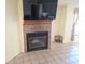 Cozy living room featuring a brick fireplace and mounted television for entertainment at 10244 Hoover St, Spring Hill, FL 34608
