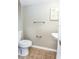 Clean half-bath with neutral wall color and tile flooring next to a pedestal sink at 10386 Norvell Rd, Spring Hill, FL 34608