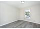 Bright bedroom features gray wood-look floors, and a window that brings in natural light at 10386 Norvell Rd, Spring Hill, FL 34608