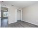 Bedroom featuring gray wood-look floors, closet with white doors, window, and a door to another room at 10386 Norvell Rd, Spring Hill, FL 34608