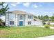 Charming two-story home with a blue front door, attached garage, and lush green lawn at 10386 Norvell Rd, Spring Hill, FL 34608