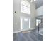Bright foyer showcasing a modern front door, high ceilings, and stylish wood-look flooring at 10386 Norvell Rd, Spring Hill, FL 34608