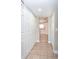 Hallway featuring tile floors and multiple closets with white doors, leading to the kitchen at 10386 Norvell Rd, Spring Hill, FL 34608