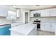 Bright kitchen featuring white cabinets, a kitchen island with white countertop, and modern appliances at 10386 Norvell Rd, Spring Hill, FL 34608