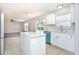 Open kitchen with an island, stainless steel appliances, bright interiors and a view of the living area at 10386 Norvell Rd, Spring Hill, FL 34608