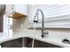 Close-up of a modern faucet and stainless steel sink with stylish stone countertops at 10386 Norvell Rd, Spring Hill, FL 34608