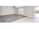 Open living room with new floors, light walls, ceiling fan, and sliding glass doors to patio at 10386 Norvell Rd, Spring Hill, FL 34608