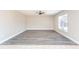 Bright, open-plan living room with stylish flooring, ceiling fan, and ample natural light at 10386 Norvell Rd, Spring Hill, FL 34608