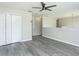 Open living room with grey flooring, modern ceiling fan, neutral walls and natural light at 10386 Norvell Rd, Spring Hill, FL 34608