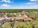 An aerial view shows homes with mature trees and landscaping nearby a body of water at 11726 Belle Haven Dr, New Port Richey, FL 34654