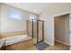 Bright bathroom featuring a walk-in shower, soaking tub, and arched windows for natural light at 11726 Belle Haven Dr, New Port Richey, FL 34654