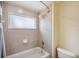 Clean bathroom featuring a shower-tub combo with neutral tile and updated fixtures and a white toilet at 11726 Belle Haven Dr, New Port Richey, FL 34654
