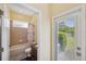 Bathroom with tub/shower combo, granite vanity, and a door leading to the backyard at 11726 Belle Haven Dr, New Port Richey, FL 34654