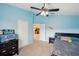 Comfortable bedroom features light blue walls, neutral carpet, and a ceiling fan for a serene and restful atmosphere at 11726 Belle Haven Dr, New Port Richey, FL 34654