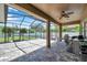Enclosed patio with neutral brick flooring providing an expansive outdoor space with views of the lawn at 11726 Belle Haven Dr, New Port Richey, FL 34654