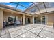 Screened patio area offers a comfortable outdoor living space with tile flooring and stylish ceiling fan at 11726 Belle Haven Dr, New Port Richey, FL 34654