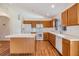 Well-lit kitchen featuring white appliances, laminate countertops, and wood cabinets at 12027 Yellow Finch Ln, Trinity, FL 34655