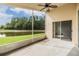 Relax on your screened lanai overlooking the serene lake and lush greenery; ceiling fan and sliding door at 12027 Yellow Finch Ln, Trinity, FL 34655