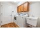 Laundry room with a white sink, wood flooring and washer and dryer at 12027 Yellow Finch Ln, Trinity, FL 34655