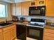 Practical kitchen featuring wood cabinetry, black appliances, and efficient layout at 1243 S Martin Luther King Jr Ave # C505, Clearwater, FL 33756