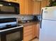 Kitchen with wood cabinets and black appliances, offering ample counter space at 1243 S Martin Luther King Jr Ave # C505, Clearwater, FL 33756