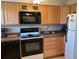 Functional kitchen with wood cabinets, black appliances, and stone countertops at 1243 S Martin Luther King Jr Ave # C505, Clearwater, FL 33756