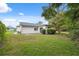 The home features a well-maintained backyard with green grass and a sliding glass door entrance at 13001 Sawmill Way, Hudson, FL 34667