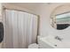 Bathroom featuring a shower with curtain, toilet, and modern sink with a large, round mirror at 13001 Sawmill Way, Hudson, FL 34667