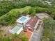 Aerial view of community center featuring pool, bocce ball court, tennis courts, and parking at 13001 Sawmill Way, Hudson, FL 34667