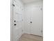 Interior hallway featuring new light colored flooring and white doors with black handles at 13001 Sawmill Way, Hudson, FL 34667