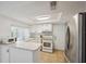A well-lit kitchen features tile floors, a skylight and white cabinetry at 13001 Sawmill Way, Hudson, FL 34667