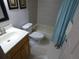 Bathroom featuring a white toilet and bathtub with light brown tile and a wooden vanity at 13010 Wedgewood Way # A, Hudson, FL 34667