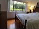 Bright bedroom featuring hardwood floors, a large window, and a traditional wooden bed at 13010 Wedgewood Way # A, Hudson, FL 34667