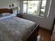 Bedroom with hardwood floors, a large window, a dark wooden headboard, and a bedside lamp at 13010 Wedgewood Way # A, Hudson, FL 34667
