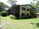 Inviting two-story home featuring screened porch, lush lawn, and mature trees at 13010 Wedgewood Way # A, Hudson, FL 34667