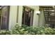 Exterior angle of condo showing windows, lighting fixture, greenery, and stairs at 13010 Wedgewood Way # A, Hudson, FL 34667
