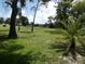 Scenic view of the lush green golf course with mature trees and a sunny sky at 13010 Wedgewood Way # A, Hudson, FL 34667