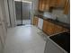 Eat-in kitchen with light countertops, white appliances, oak cabinets, and a sliding glass door at 13010 Wedgewood Way # A, Hudson, FL 34667