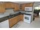 Kitchen featuring oak cabinetry, granite countertops, white appliances, and tiled backsplash at 13010 Wedgewood Way # A, Hudson, FL 34667