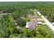 Aerial view of the property, house and detached garage, nestled in a verdant, wooded area at 13444 English Parrot Rd, Brooksville, FL 34614