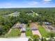 Aerial view of home with detached garage on a lush lot amidst a green, wooded neighborhood at 13444 English Parrot Rd, Brooksville, FL 34614