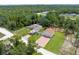 An aerial view showcases the home, detached garage and long driveway nestled amongst the trees at 13444 English Parrot Rd, Brooksville, FL 34614