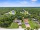 Wide aerial view of the property amidst a lush green landscape with surrounding homes at 13444 English Parrot Rd, Brooksville, FL 34614