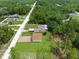 Aerial view of home with detached garage surrounded by lush greenery and neighborhood at 13444 English Parrot Rd, Brooksville, FL 34614