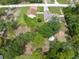 Aerial view of the property featuring a fire pit, house, detached garage and green surroundings at 13444 English Parrot Rd, Brooksville, FL 34614